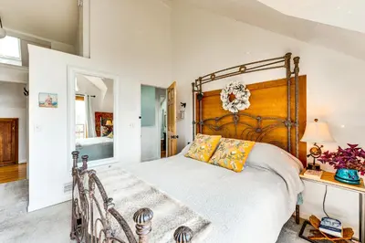 a bedroom with a large bed with a wooden headboard at Trail Access, Hot Tub Lakefront Boulder Retreat! in Boulder