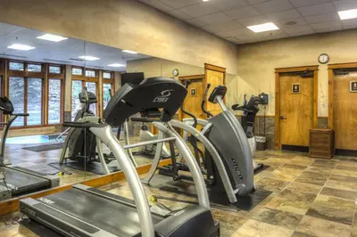 a gym with treadmills and ellipticals in a room at Timbers 3074 in Keystone