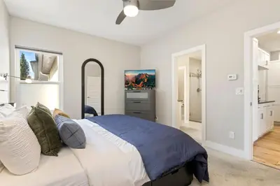 a bedroom with a large bed and a mirror at Rams Roost with Rooftop Hot Tub, Patio and Family Fun in Fort Collins