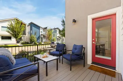 a patio with blue chairs and a red door at Rams Roost with Rooftop Hot Tub, Patio and Family Fun in Fort Collins