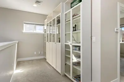 a walk in closet with white cabinets at Rams Roost with Rooftop Hot Tub, Patio and Family Fun in Fort Collins