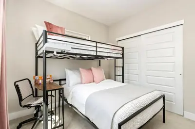 a bedroom with a bunk bed and a chair at Rams Roost with Rooftop Hot Tub, Patio and Family Fun in Fort Collins