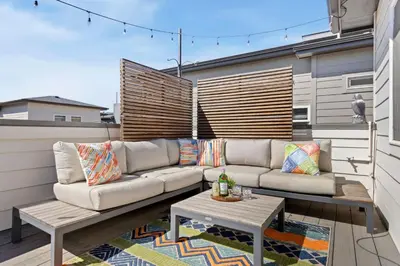 a patio with a couch and a table on a balcony at Rams Roost with Rooftop Hot Tub, Patio and Family Fun in Fort Collins