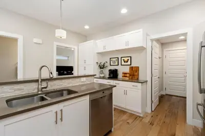 a kitchen with white cabinets and a sink at Rams Roost with Rooftop Hot Tub, Patio and Family Fun in Fort Collins
