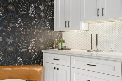 a kitchen with white cabinets and a floral wallpaper at Shade Tree Bungalow in Old Town, Yard & Garage in Fort Collins