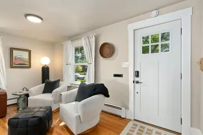 a living room with two chairs and a door at Shade Tree Bungalow in Old Town, Yard & Garage in Fort Collins