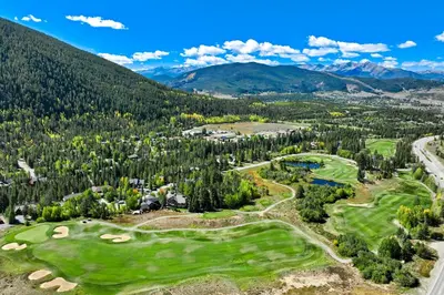 an aerial view of a golf course with mountains in the background at Soda Springs Ski Retreat - Heated Pool & Hot Tub in Keystone