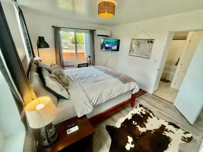 a bedroom with a bed and a television in it at Pet Friendly Suite with Fenced Garden, HotTub, Sauna in Denver