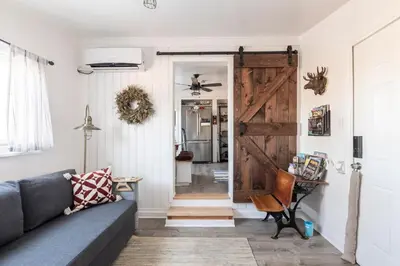 a living room with a couch and a barn door at Pet Friendly Suite with Fenced Garden, HotTub, Sauna in Denver