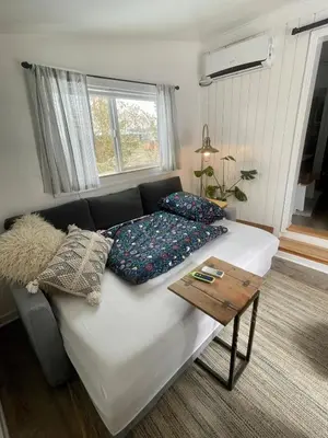 a couch with pillows on it in a living room at Pet Friendly Suite with Fenced Garden, HotTub, Sauna in Denver