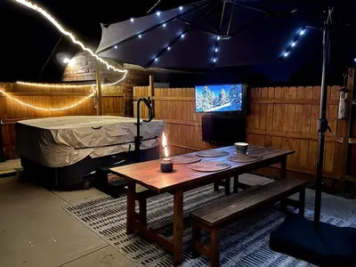 a room with a table and a bed with lights at Pet Friendly Suite with Fenced Garden, HotTub, Sauna in Denver