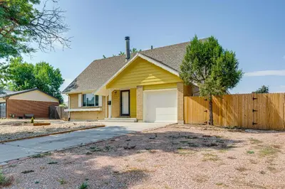 a yellow house with a wooden fence at 2 Mi to Hospitals Home with Private Yard in Aurora in Aurora