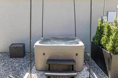 a bath tub with a chair next to some plants at Olde Town Gem 5 TVs Hot Tub & Game Yard in Arvada