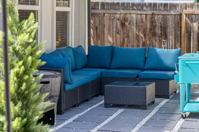 a blue couch sitting on a patio at Olde Town Gem 5 TVs Hot Tub & Game Yard in Arvada