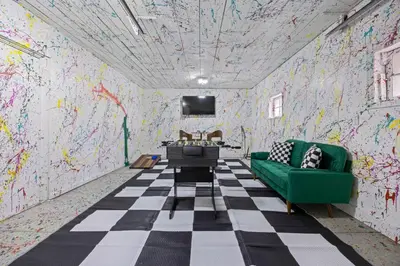 a room with a green couch and a wall covered in graffiti at Olde Town Gem 5 TVs Hot Tub & Game Yard in Arvada