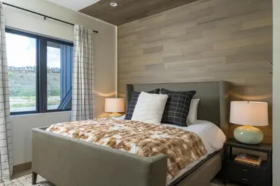 a bedroom with a bed with two lamps and a window at Lodge 212 Brand New LUXE Designer Home and Hot Tub in Fraser