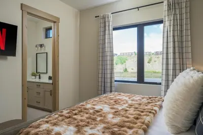 a bedroom with a bed with a large window at Lodge 212 Brand New LUXE Designer Home and Hot Tub in Fraser