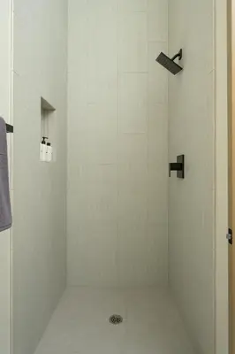 a shower with a white tiled shower stall at Lodge 212 Brand New LUXE Designer Home and Hot Tub in Fraser