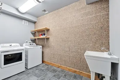 a laundry room with a washer and dryer and a brick wall at Mountain Getaway Deck Spacious Kitchen in Silverthorne