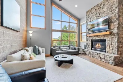 a living room with a fireplace and a stone wall at Mountain Getaway Deck Spacious Kitchen in Silverthorne