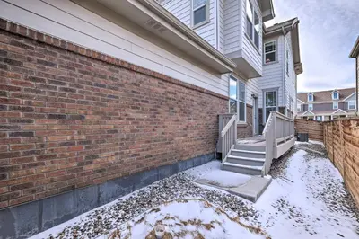 a house with snow on the ground next to a brick wall at Charming 3BR Retreat - Perfect for Families in Fort Collins