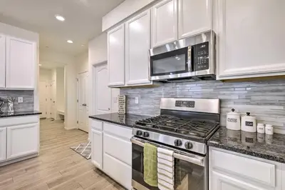 a kitchen with white cabinets and a stove top oven at Charming 3BR Retreat - Perfect for Families in Fort Collins