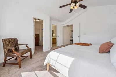 a bedroom with a bed and a chair and a ceiling fan at 3BR Modern Retreat, Close to DIA & Downtown Denver in Commerce City