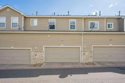 a building with four garage doors in front of it at 3BR Modern Retreat, Close to DIA & Downtown Denver in Commerce City
