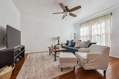 a living room with a blue couch and a ceiling fan at 3BR Modern Retreat, Close to DIA & Downtown Denver in Commerce City