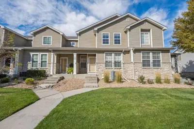 a large house with a lawn in front of it at 3BR Modern Retreat, Close to DIA & Downtown Denver in Commerce City