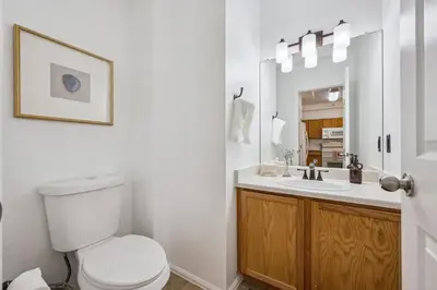 a white bathroom with a toilet and a sink at 3BR Modern Retreat, Close to DIA & Downtown Denver in Commerce City