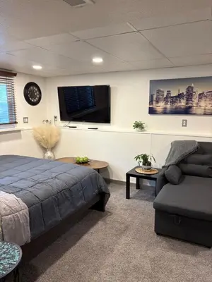 a bedroom with a bed and a couch and a tv at The Cozy nest in Englewood