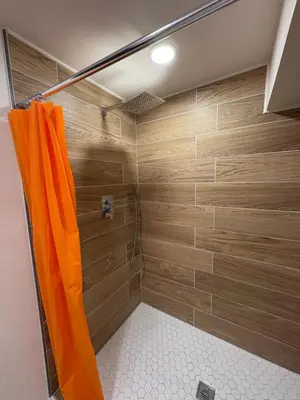 a shower with wooden walls and a shower curtain at The Cozy nest in Englewood