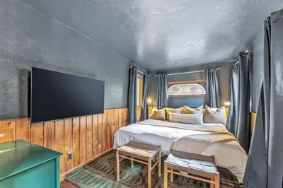 a bedroom with a bed and a flat screen tv at Dog Friendly, Year Round, Creekside Cabin, Hot Tub, 6 Acres in Jamestown