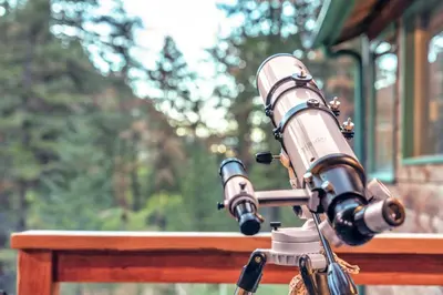 a telescope sitting on top of a wooden fence at Dog Friendly, Year Round, Creekside Cabin, Hot Tub, 6 Acres in Jamestown