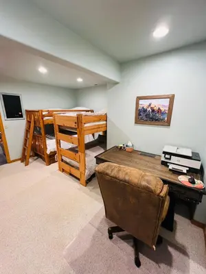 a living room with a desk and a bunk bed at Granby Panoramic Paradise! Hot tub and firepit! in Granby