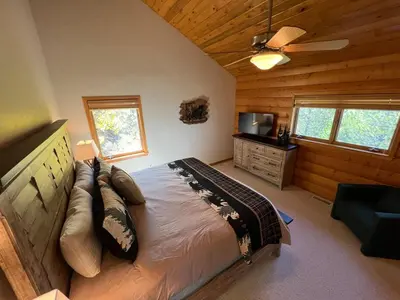 a bedroom with a bed and a ceiling fan at Granby Panoramic Paradise! Hot tub and firepit! in Granby