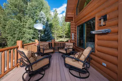 a wooden deck with chairs and a house at Granby Panoramic Paradise! Hot tub and firepit! in Granby