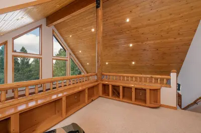 an empty room with wooden walls and windows at Granby Panoramic Paradise! Hot tub and firepit! in Granby