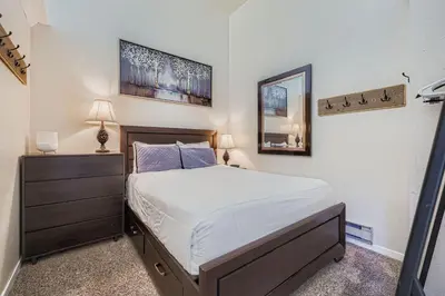 a bedroom with a bed and a dresser and a mirror at 2795 Slopeside condo in Keystone