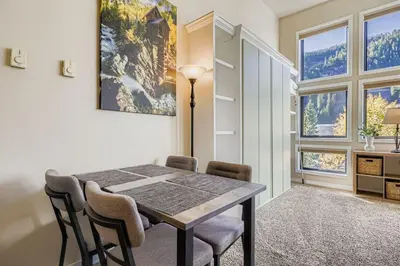 a dining room with a table and chairs and windows at 2795 Slopeside condo in Keystone