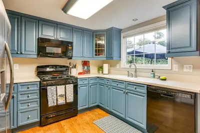 a kitchen with blue cabinets and a window at Spacious Family Home with Deck and Yard in Littleton! in Littleton
