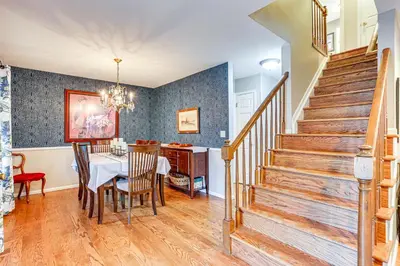 a dining room and living room with a table and stairs at Spacious Family Home with Deck and Yard in Littleton! in Littleton