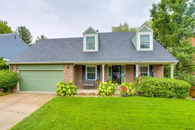 a house with a green garage and a lawn at Spacious Family Home with Deck and Yard in Littleton! in Littleton