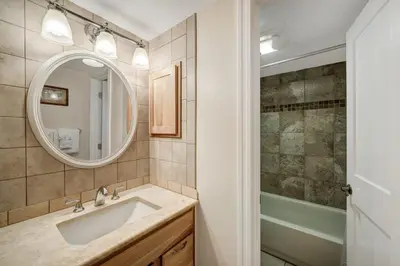 a bathroom with a sink and a mirror and a shower at Keystone Mtn Getaway - Cozy Condo for 4 in Keystone