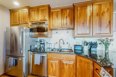a kitchen with wooden cabinets and a stainless steel refrigerator at Timber Ridge Escape in Silverthorne