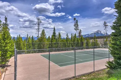 a tennis court with a mountain in the background at Timber Ridge Escape in Silverthorne