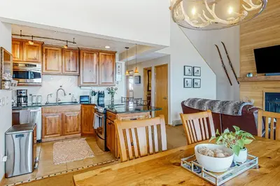 a kitchen with wooden cabinets and a wooden table at Timber Ridge Escape in Silverthorne