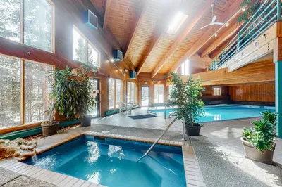an indoor pool in a house with windows at Timber Ridge Escape in Silverthorne