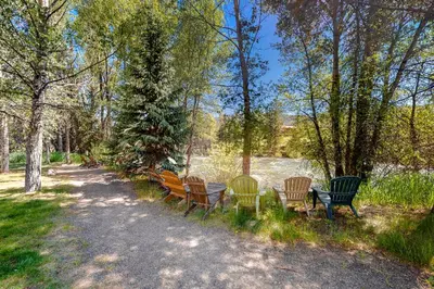 a row of park benches sitting next to a river at Blue River Bliss in Silverthorne